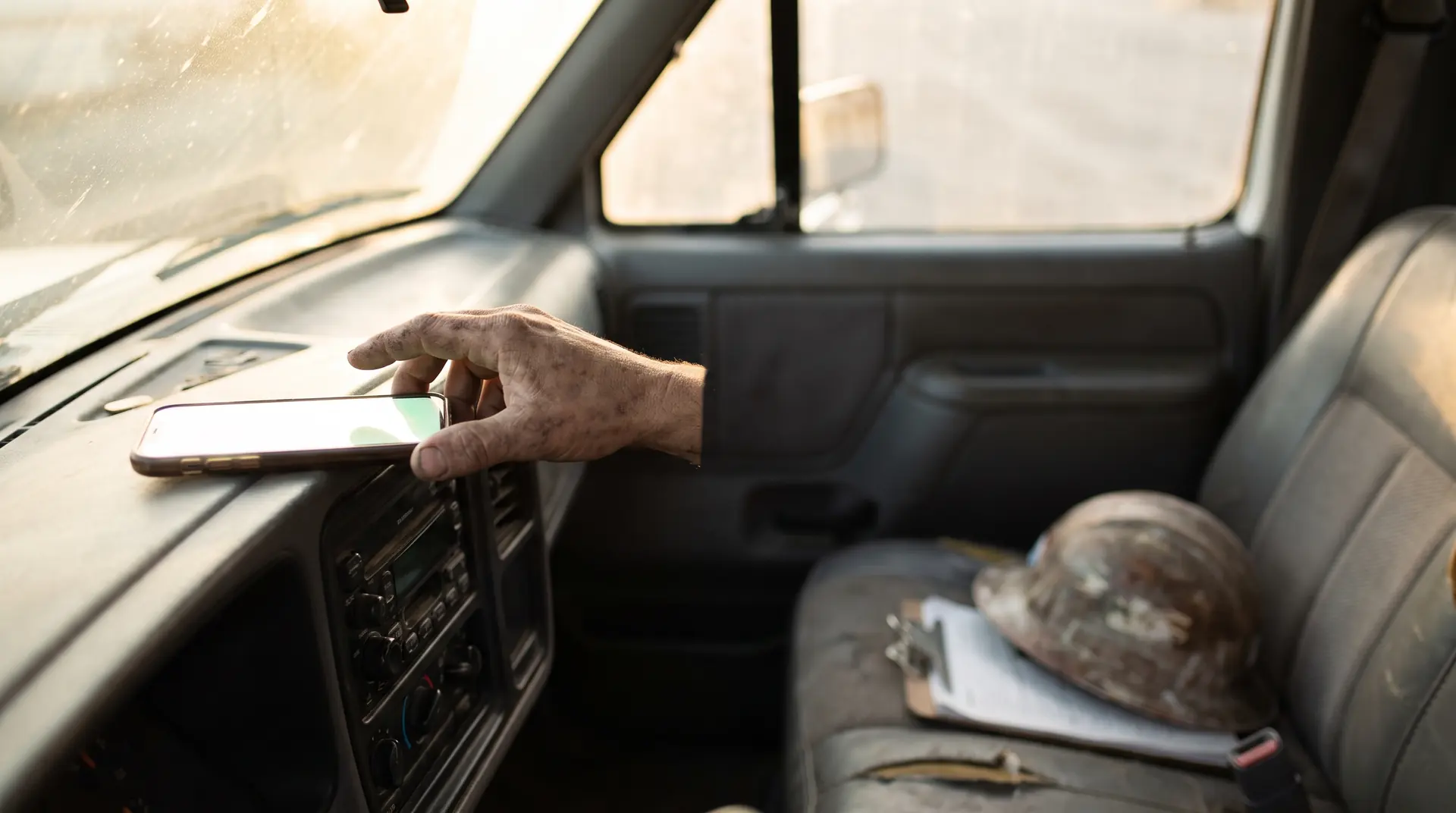 A contractor in his truck picking up his phone